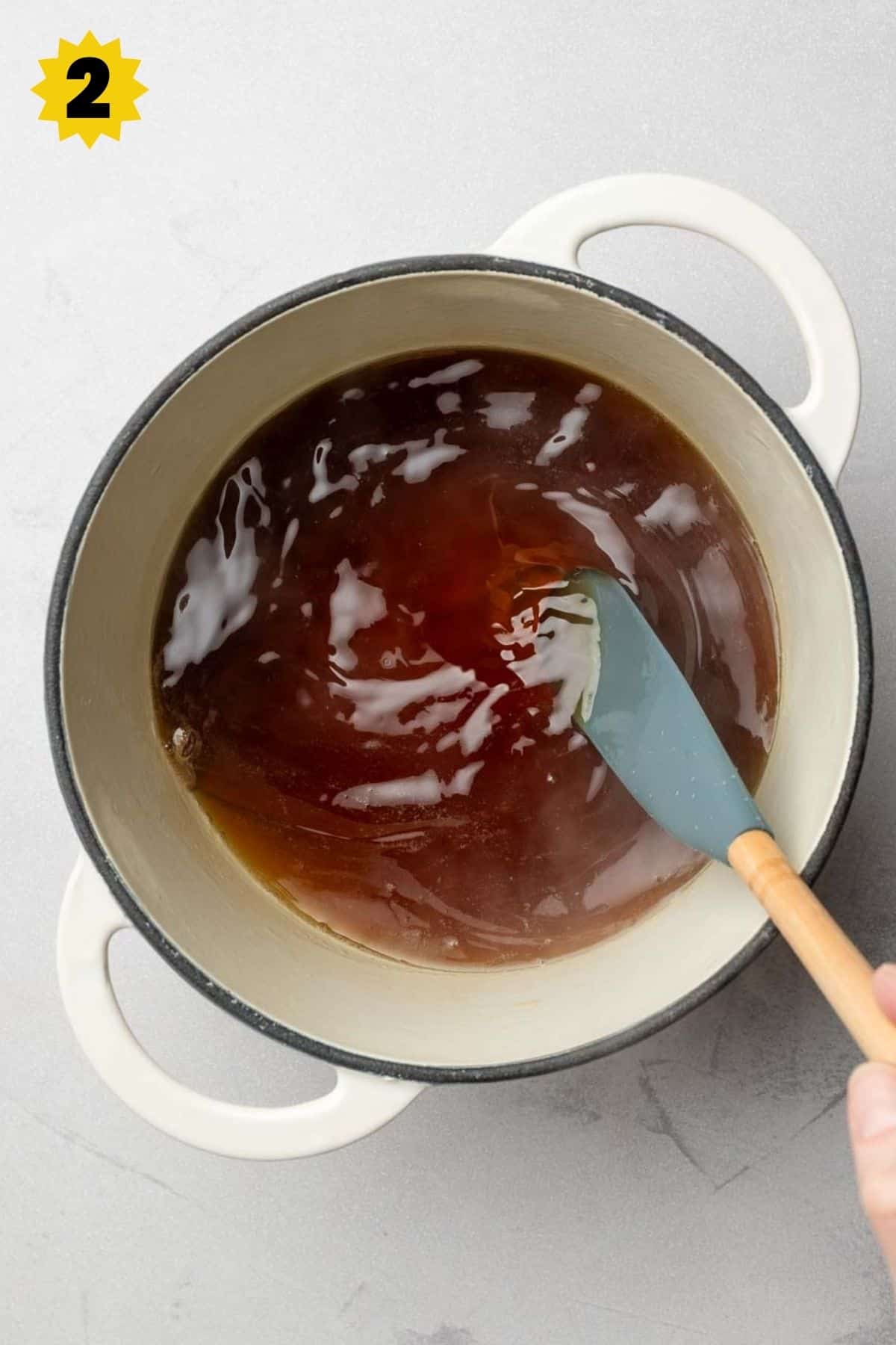 Stirring brown sugar syrup in small pot, mixture is a clear brown color.