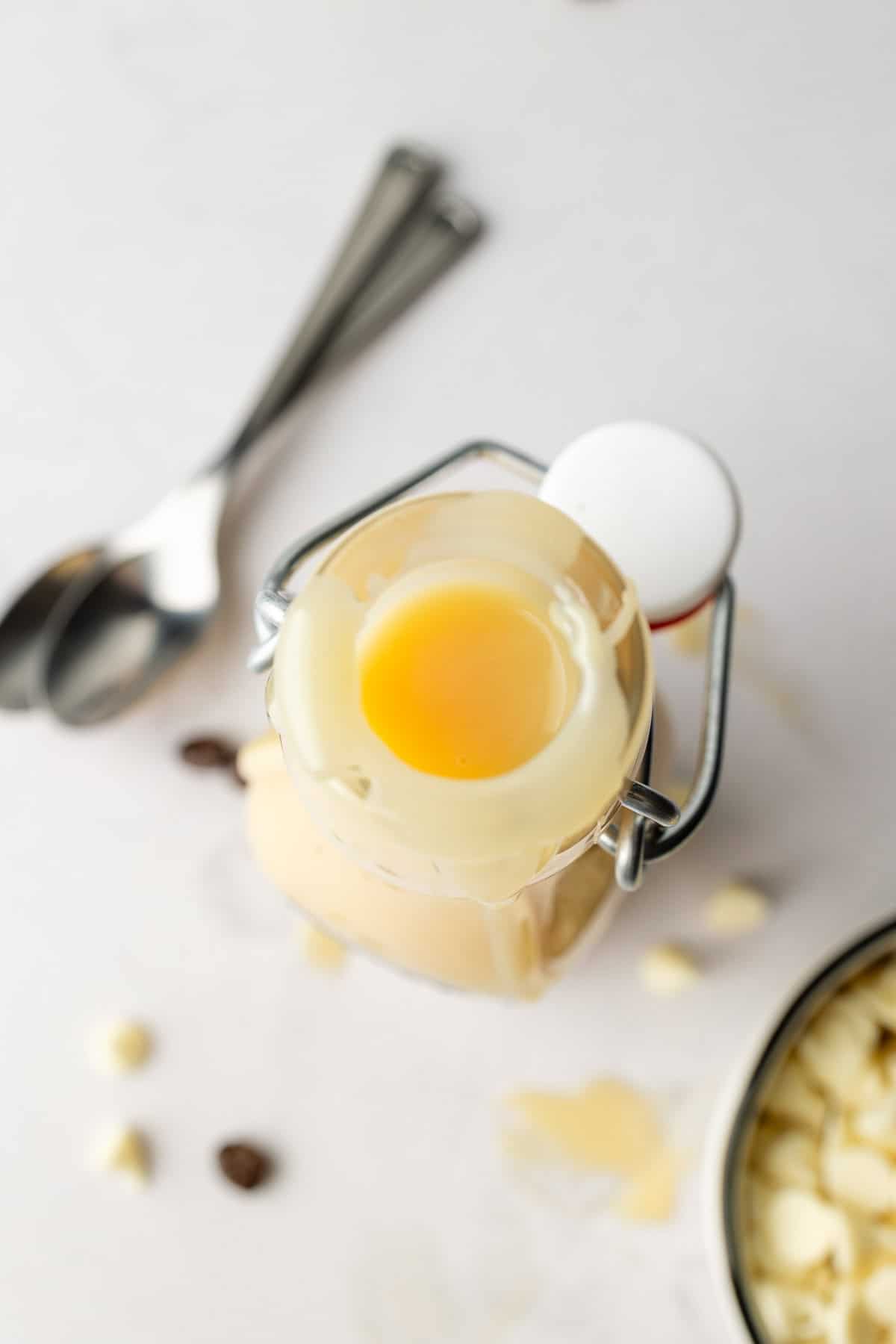 View of white chocolate sauce through top of the bottle opening.