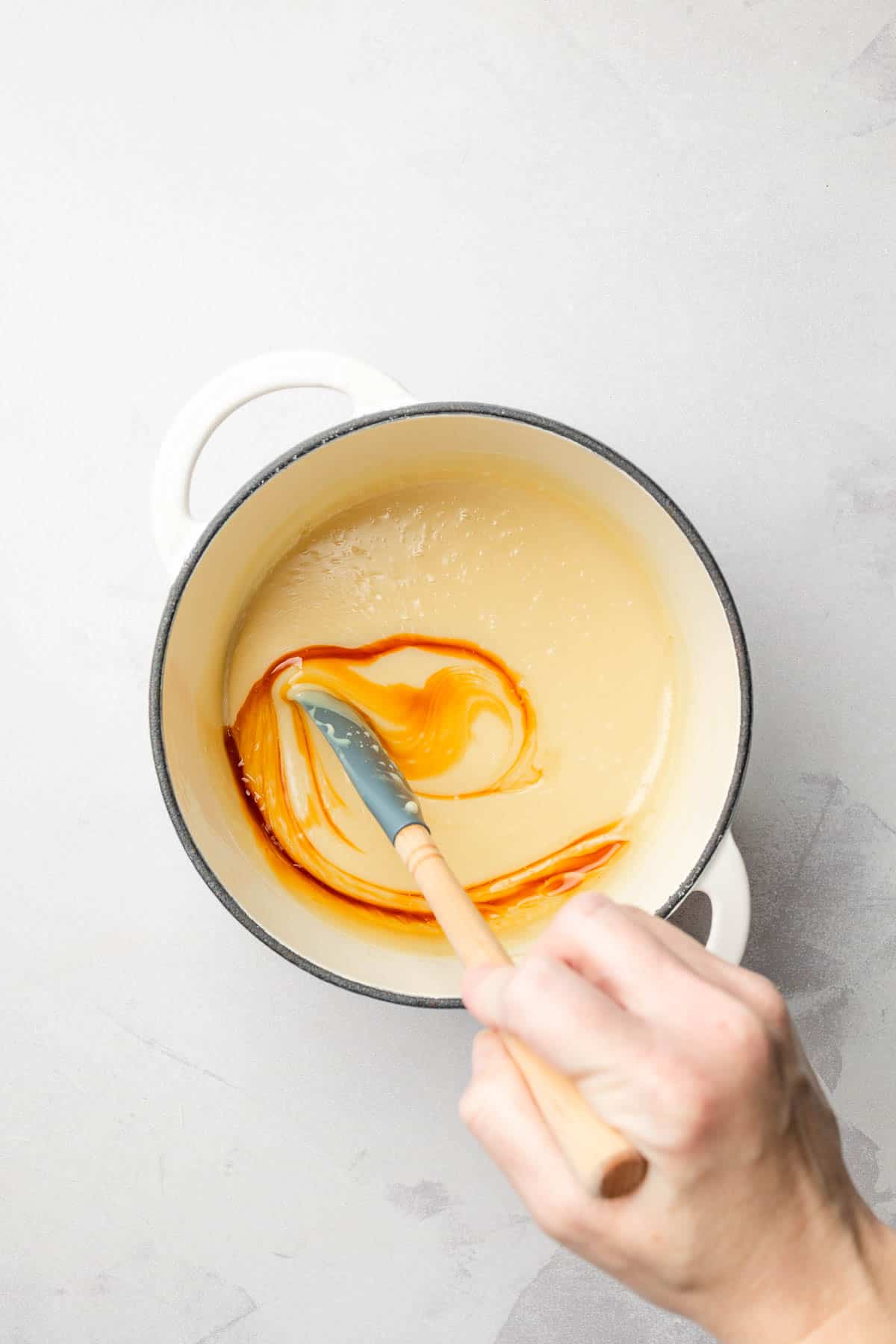 Stirring vanilla into the white chocolate sauce.