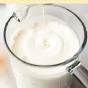 A spoon lifted above the prepared sweet cream mixture, with a drop falling back into the glass measuring cup.