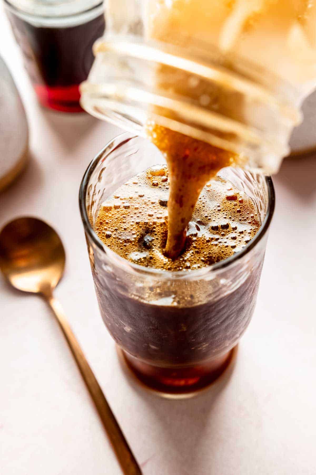 Pouring shaken espresso over ice.