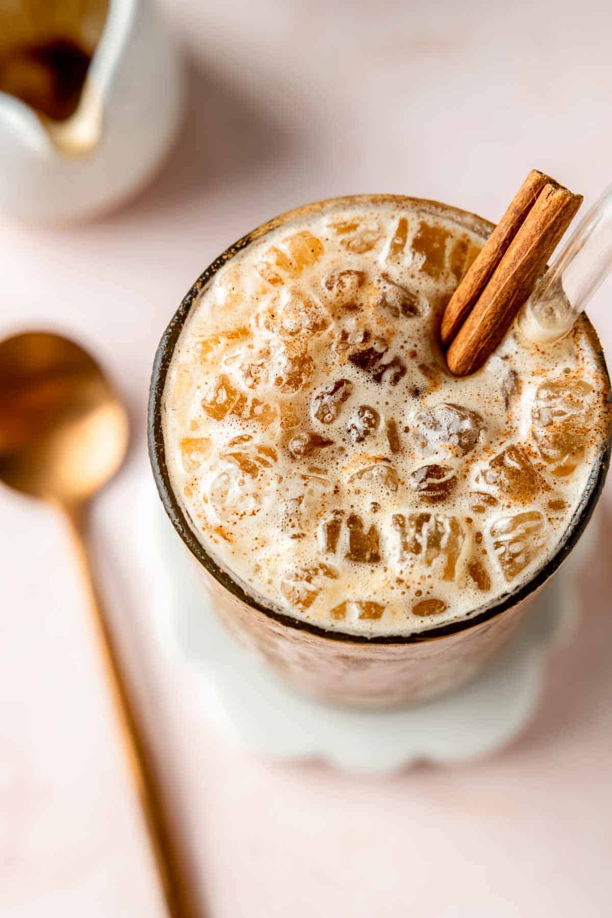 Brown sugar shaken espresso in glass with crushed ice and garnished with a cinnamon stick.