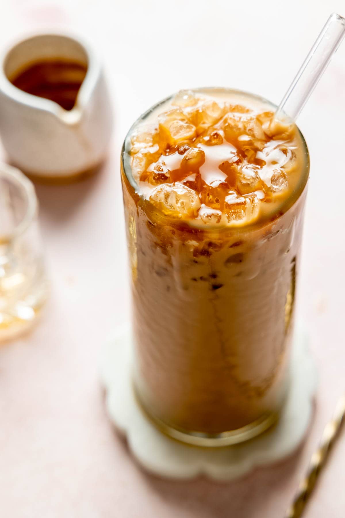 Iced caramel latte in a tall glass topped with caramel drizzle. 