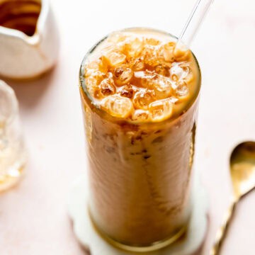Iced caramel latte in a tall glass topped with caramel drizzle.
