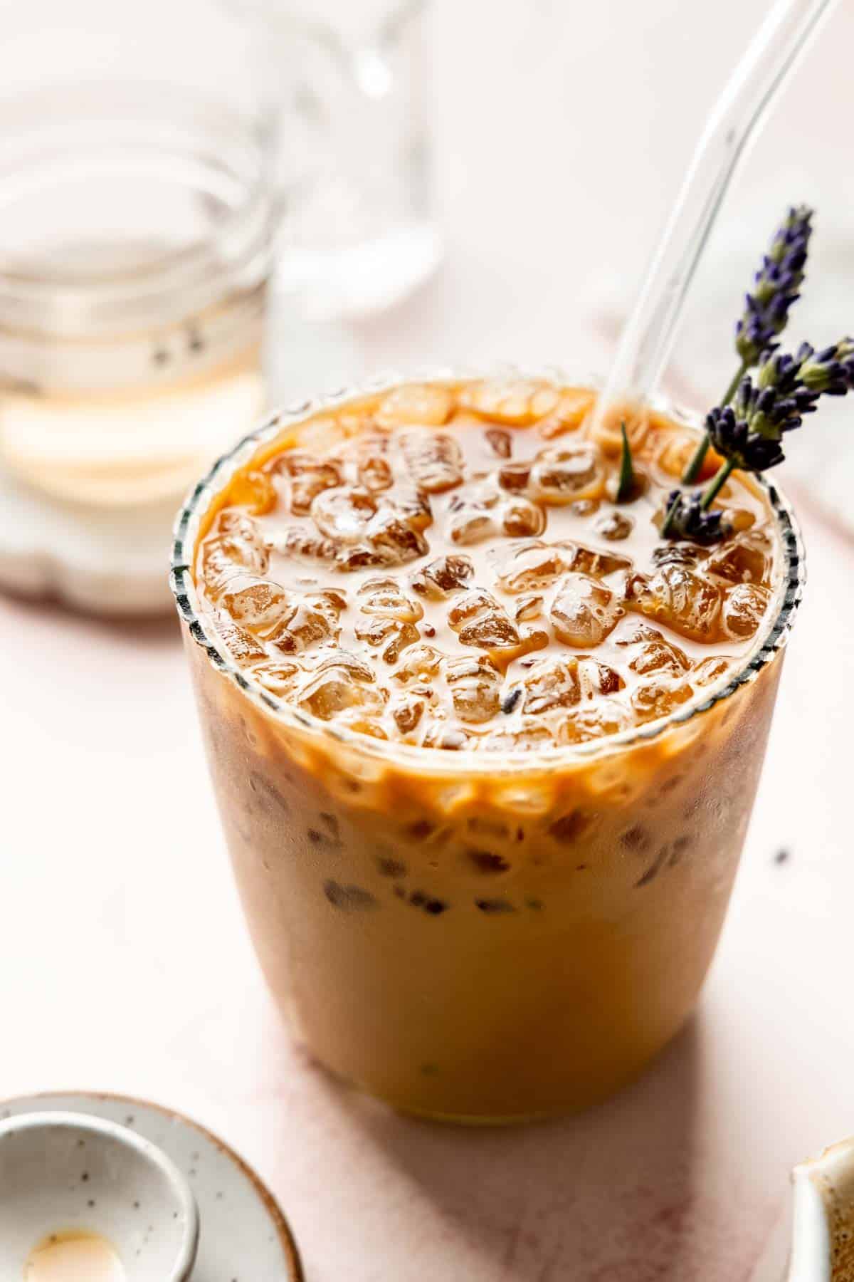 Iced lavender latte with crushed ice and lavender garnish.
