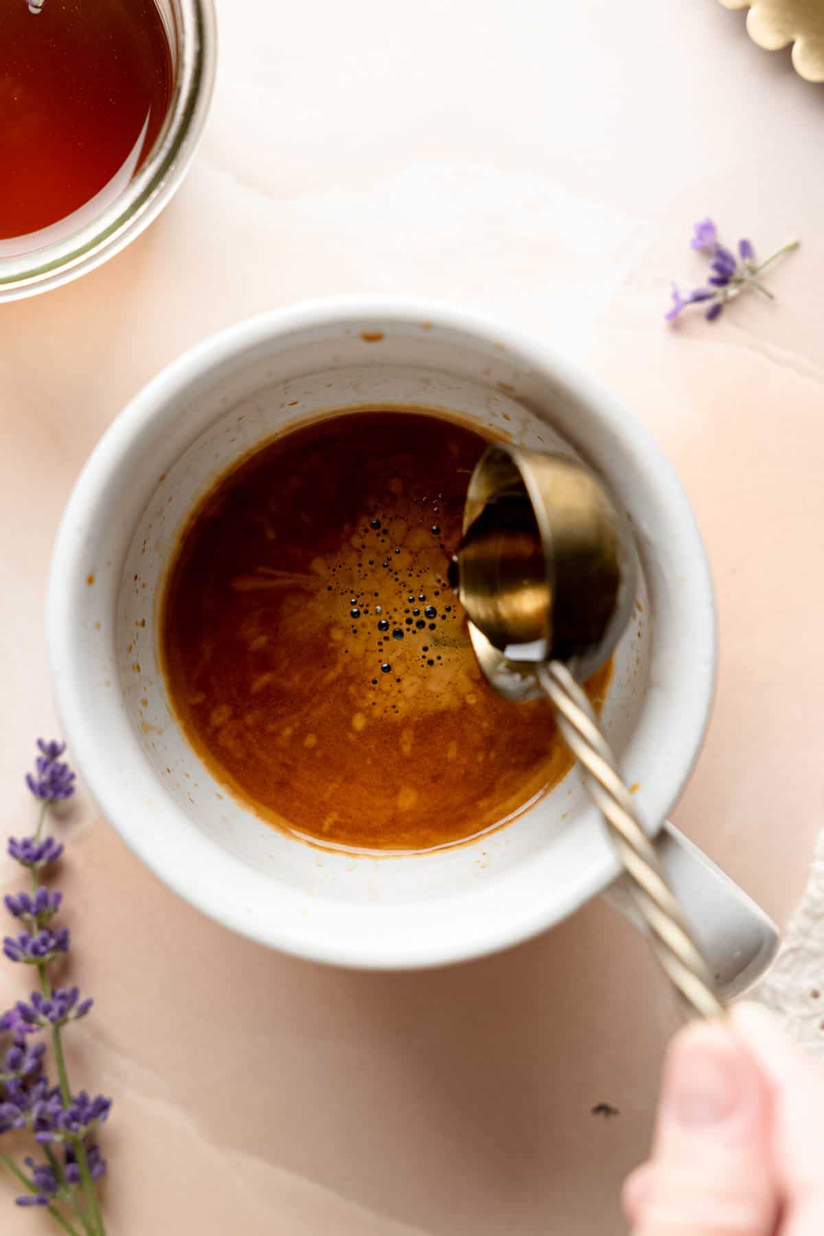 Pouring a tablespoon of lavender syrup into espresso glass.